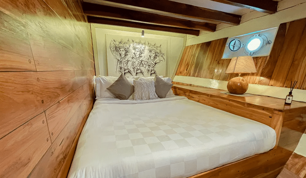 3 days shared trip. Cozy bedroom with a wooden interior, a large bed, decorative art on the wall, and warm lighting.