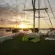 3 days shared trip. Sunset over a marina, viewed from the deck of a boat, with small boats in the water and vibrant clouds in the sky.